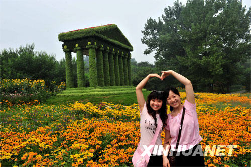 7月27日，游客在北京植物园举办的“五环连五洲”世界花卉展上留影留念。