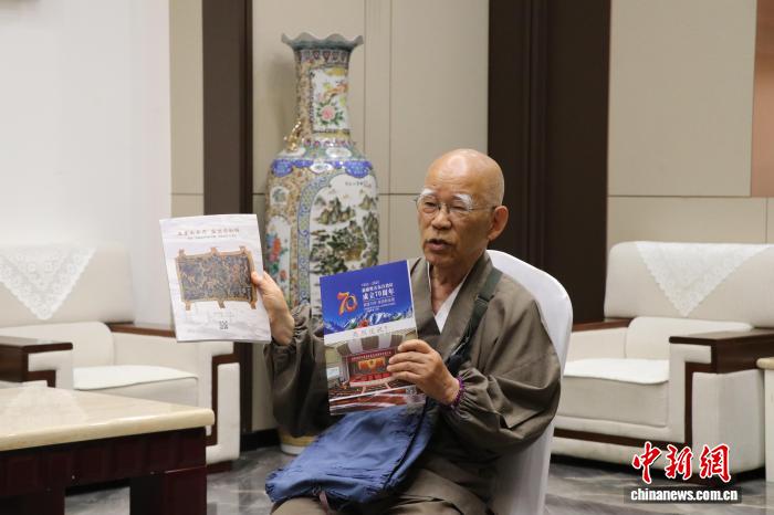6月21日、自身が執筆した新疆関連の書籍を見せる小島康誉氏（撮影・苟継鵬）。