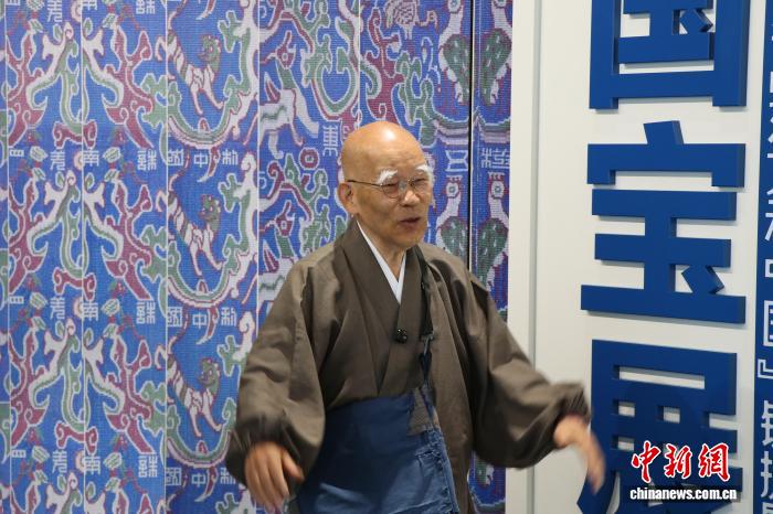 6月21日、新疆博物館で、「中華錦繍——五星出東方利中国『錦護臂国宝展』」を見学する小島康誉氏（撮影・苟継鵬）。